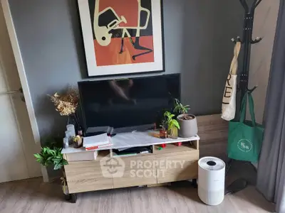 Stylish living room corner with modern TV stand, artwork, and indoor plants for a cozy ambiance.