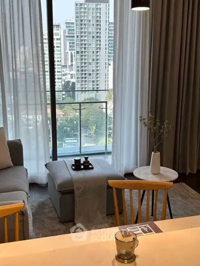 Modern living room with city view, cozy seating, and elegant decor in a high-rise apartment.