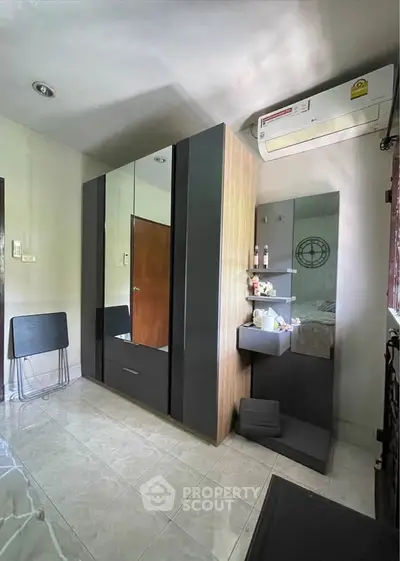 Modern bedroom with sleek wardrobe and air conditioning