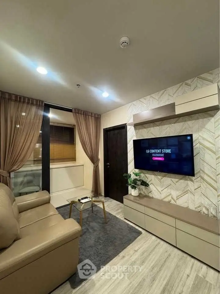 Modern living room with stylish decor and wall-mounted TV, featuring cozy seating and elegant lighting.