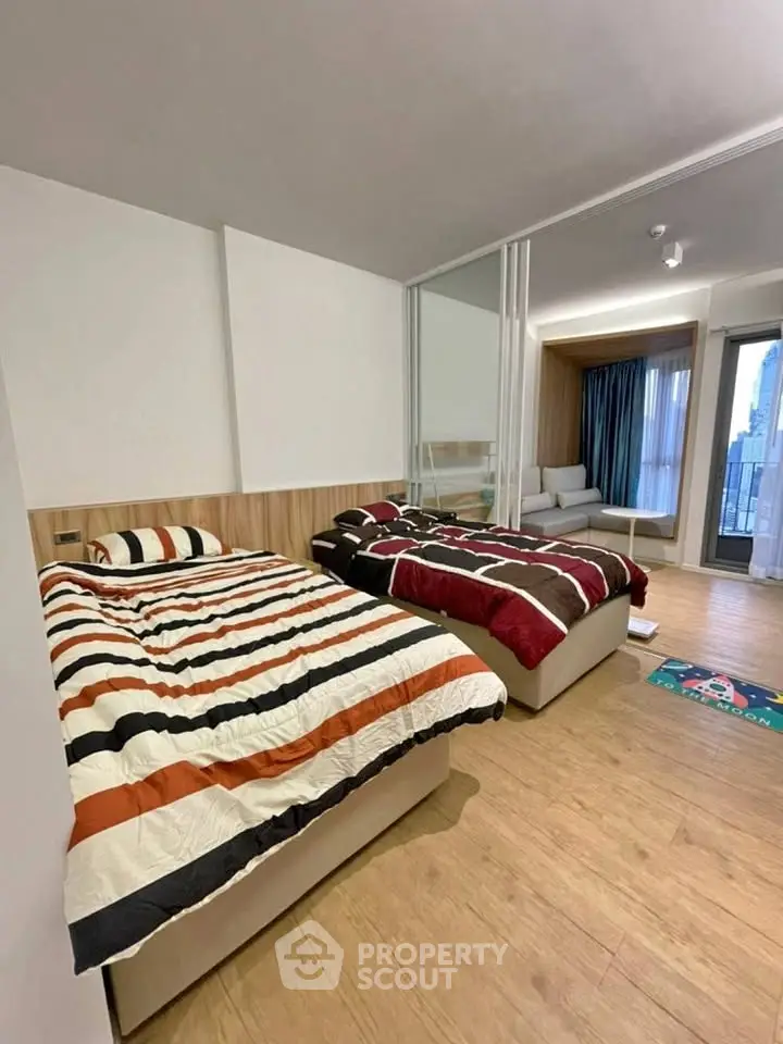 Modern bedroom with twin beds and balcony access in stylish apartment