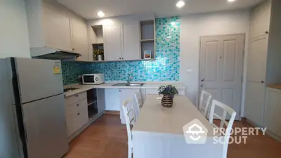 Modern kitchen with blue mosaic backsplash and dining table in stylish apartment