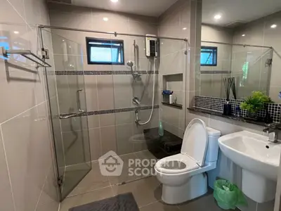 Modern bathroom with glass shower enclosure and sleek fixtures