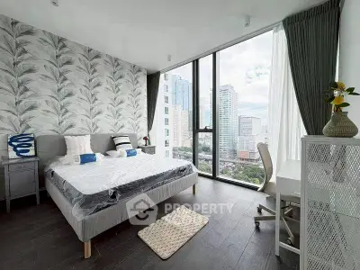 Modern bedroom with large windows offering stunning city views, stylish decor, and cozy furnishings.