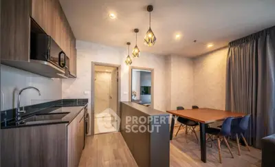 Modern kitchen and dining area with stylish lighting and wooden finishes.