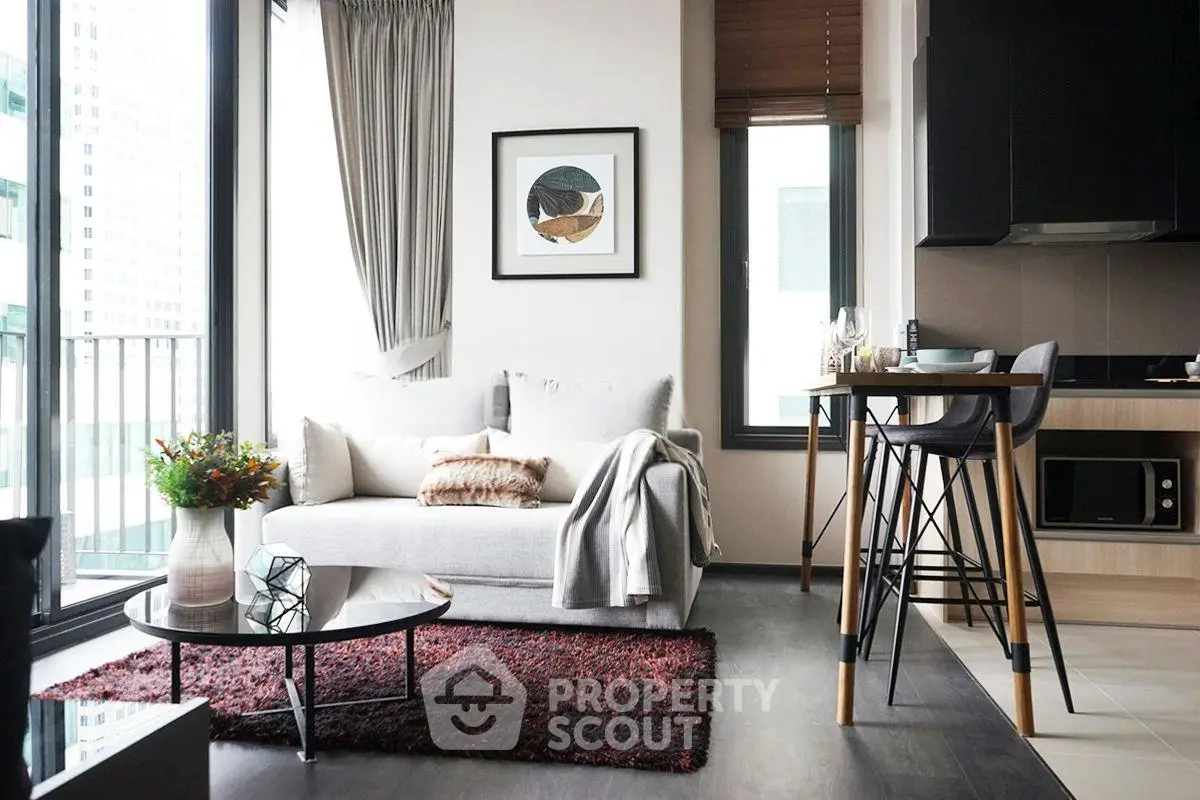 Modern living room with stylish decor and large windows in a high-rise apartment.