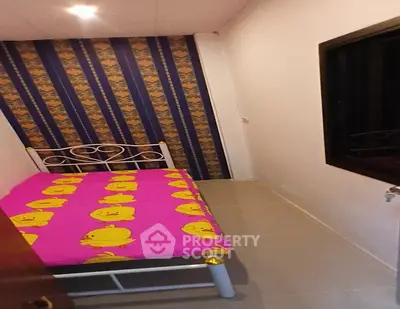 Cozy small bedroom with vibrant pink bedding and stylish wallpaper accent wall.