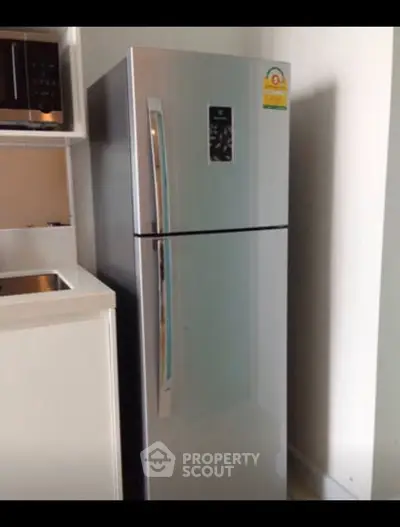 Modern kitchen with sleek stainless steel refrigerator and built-in microwave.