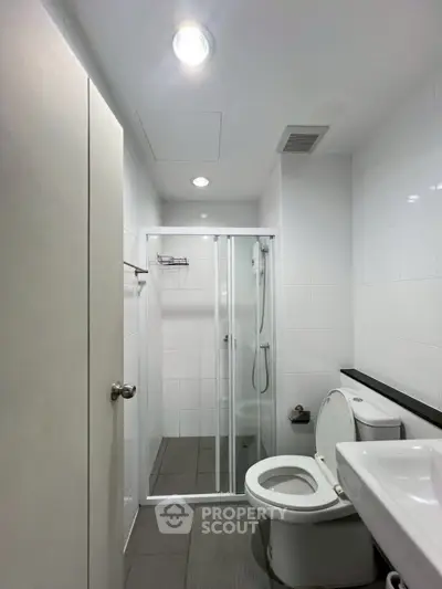 Modern bathroom with sleek shower and contemporary fixtures in a stylish apartment.