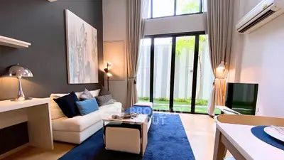 Modern living room with high ceilings, large windows, and stylish decor in a luxury apartment.