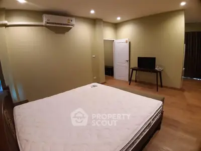 Spacious bedroom with air conditioning and modern furnishings in a cozy apartment.