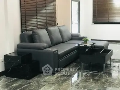 Modern living room with sleek gray sofa and marble flooring, perfect for stylish urban living.