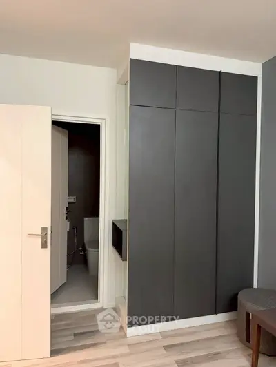 Modern bathroom entrance with sleek storage cabinets and stylish flooring