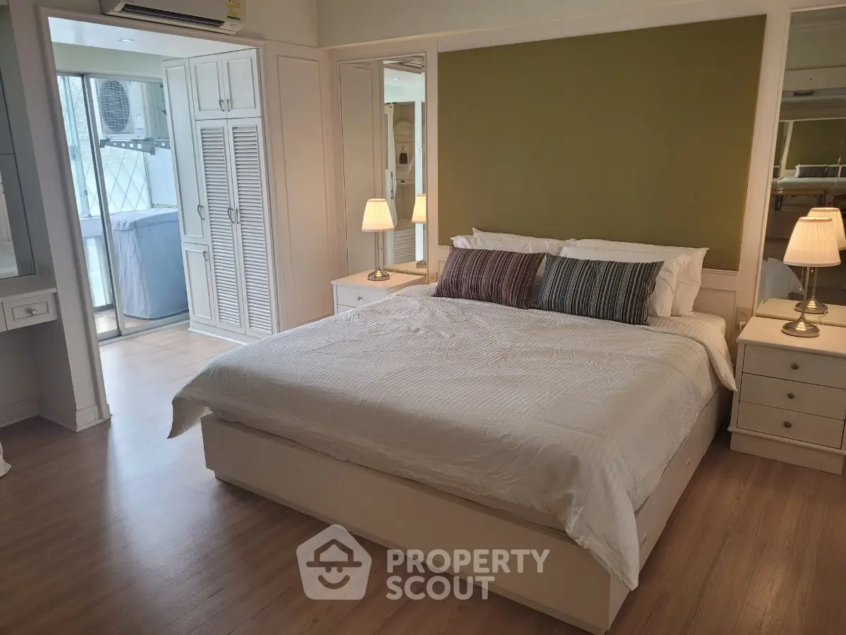 Spacious bedroom with modern decor and balcony access in a stylish apartment.