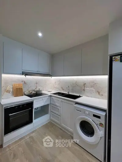 Modern kitchen with sleek appliances and elegant marble backsplash
