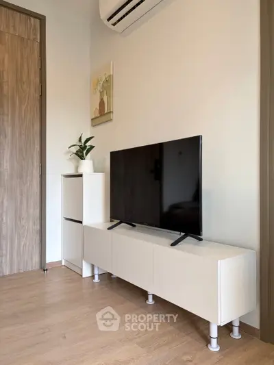 Modern living room with sleek TV stand and wall-mounted air conditioner, perfect for cozy entertainment.