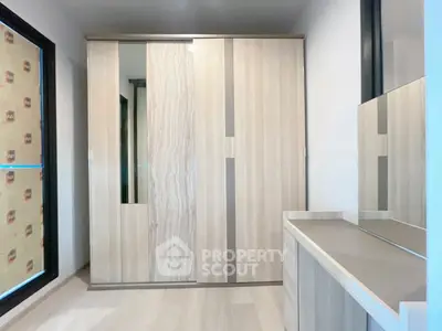 Modern bedroom with sleek wardrobe and dresser, featuring minimalist design and ample storage space.