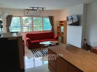Spacious living room with modern furniture and large windows offering a scenic view.