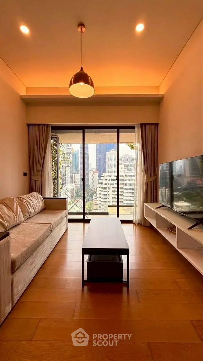 Modern living room with city view, featuring sleek furniture and large windows for natural light.