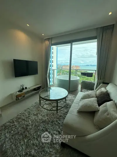 Luxurious living room with plush rug, modern sofa, and stunning balcony view.
