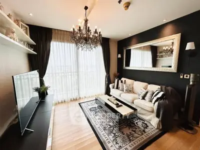 Luxurious living room with elegant chandelier and floor-to-ceiling windows offering stunning views.