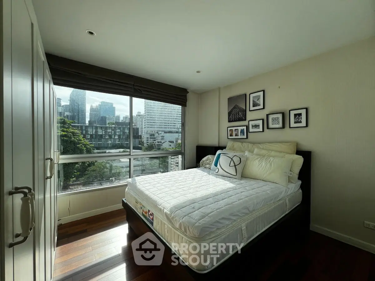 Cozy bedroom with city view, featuring a comfortable bed and stylish decor.