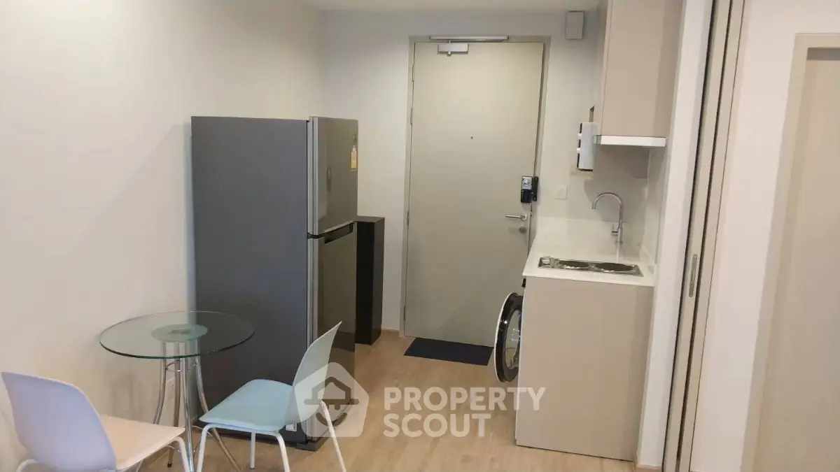 Compact modern kitchen with fridge and washing machine in cozy apartment