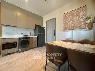 Modern kitchen with sleek cabinets, marble dining table, and integrated appliances for stylish living.