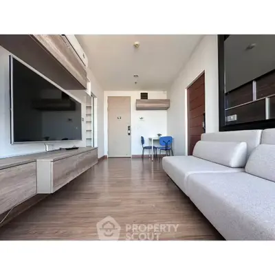 Modern living room with sleek furniture and wall-mounted TV in a stylish apartment.
