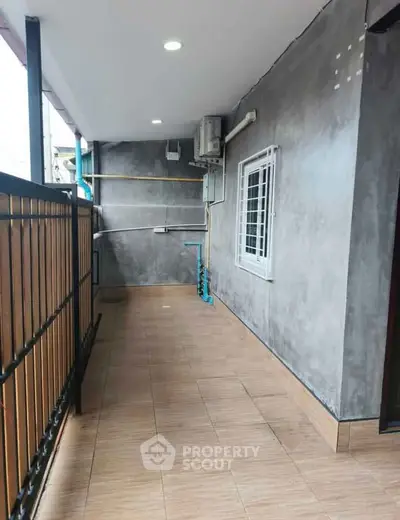 Spacious balcony with modern railing and tiled flooring, perfect for outdoor relaxation.