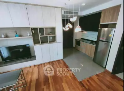 Modern open-layout kitchen with sleek appliances and stylish wooden flooring.