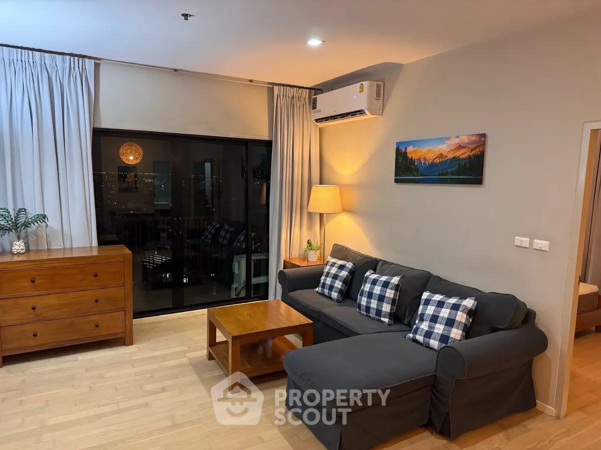 Cozy living room with modern decor and city view, featuring a comfortable sofa and stylish wooden furniture.