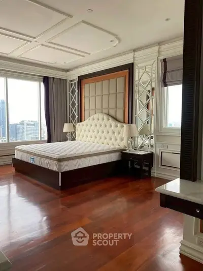Luxurious bedroom with city view, elegant decor, and hardwood floors in upscale property.
