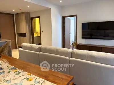 Modern living room with stylish decor and wall-mounted TV in a cozy apartment.