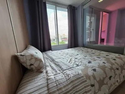 Cozy bedroom with floral bedding and large window offering natural light and city view.