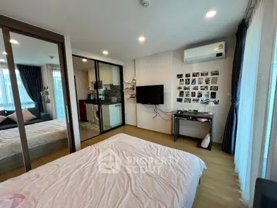 Modern bedroom with mirrored closet, wall-mounted TV, and cozy decor in a stylish apartment.