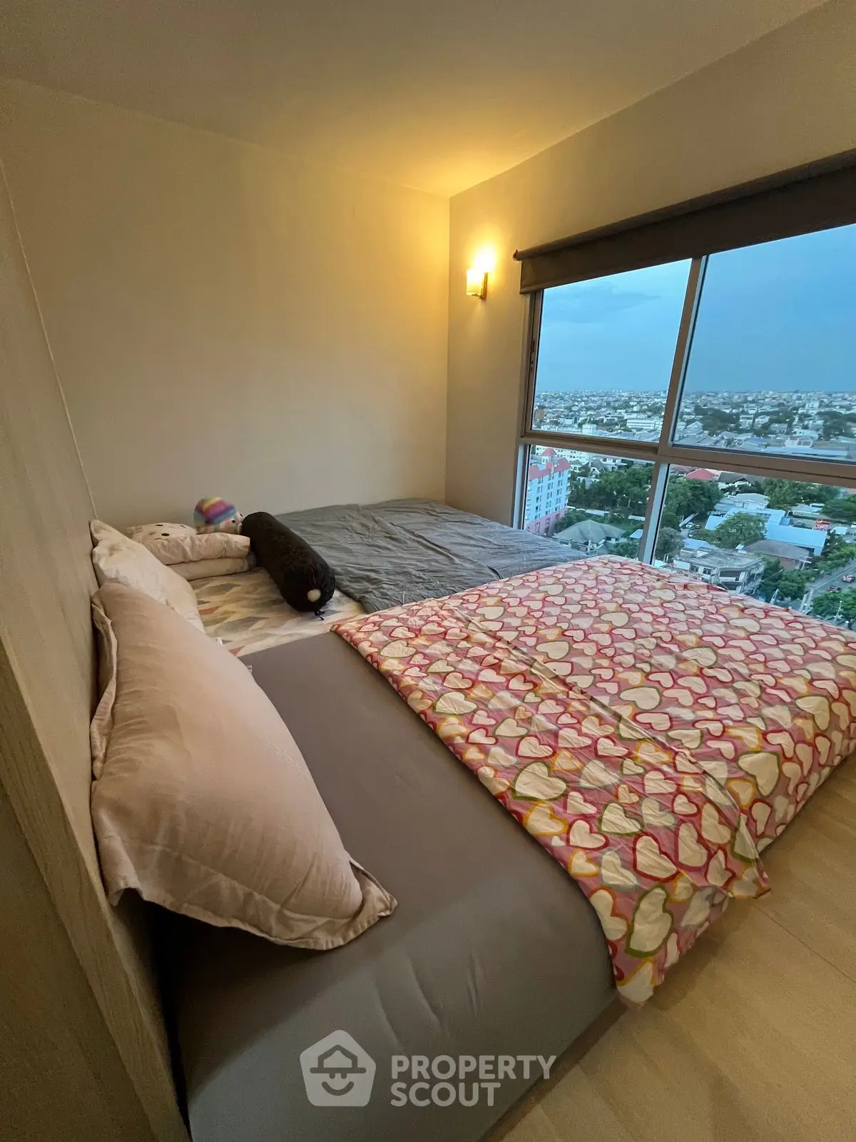 Cozy bedroom with large window offering stunning city views