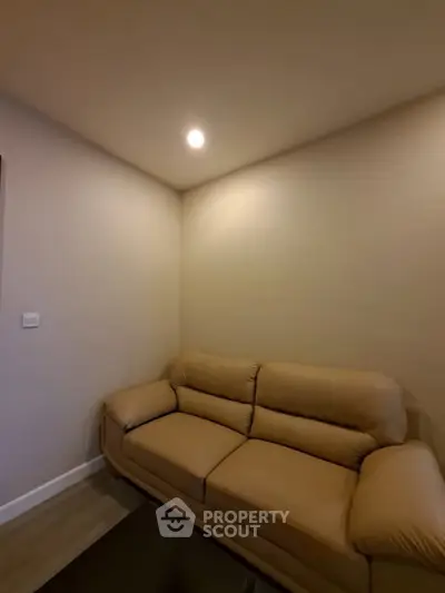 Cozy living room with a comfortable beige sofa and warm lighting, perfect for relaxation.