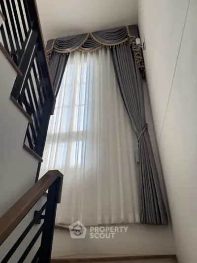 Elegant staircase with luxurious drapery and natural light