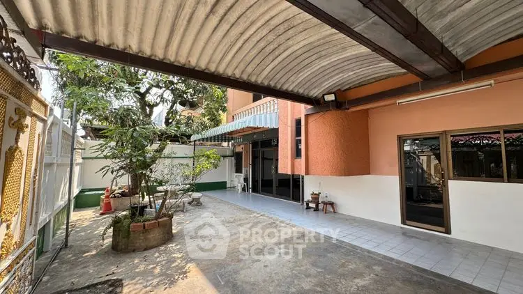 Spacious covered patio with garden area in a charming residential property.