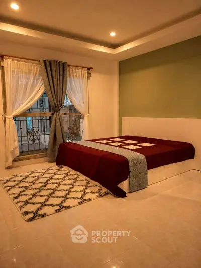 Cozy bedroom with elegant decor and large window offering natural light