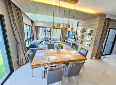 Spacious open-plan living and dining area with modern decor and large windows.