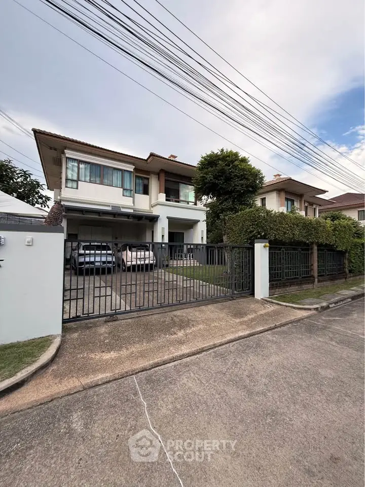 Elegant two-story house with spacious driveway and lush greenery in a serene neighborhood.