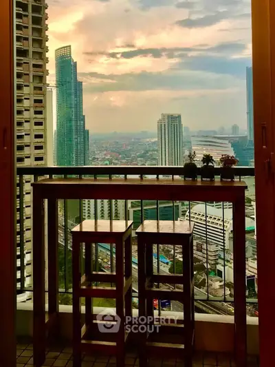 Stunning cityscape view from a high-rise balcony with stylish seating, perfect for urban living enthusiasts.