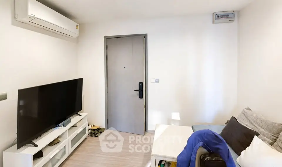 Cozy living room with modern TV setup and air conditioning, perfect for relaxation.