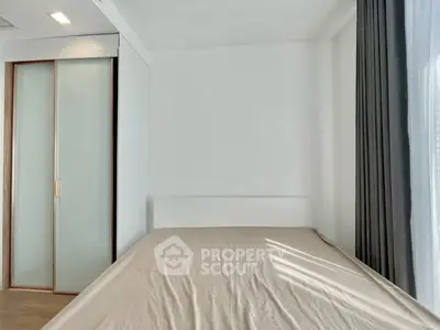 Minimalist bedroom with sleek sliding closet doors and large window with curtains.