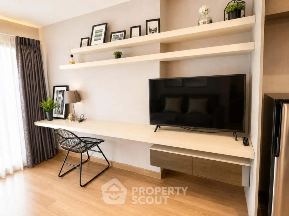 Modern living room with sleek TV setup and stylish shelving in a cozy apartment.