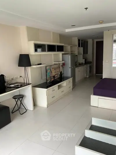 Modern studio apartment with sleek furniture and open kitchen layout, ideal for urban living.