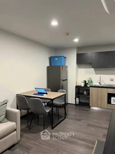 Modern kitchen with dining area, featuring sleek cabinetry and contemporary appliances.