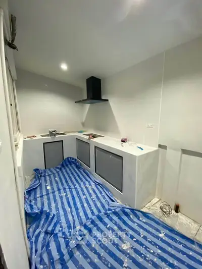 Modern kitchen under renovation with sleek cabinetry and range hood